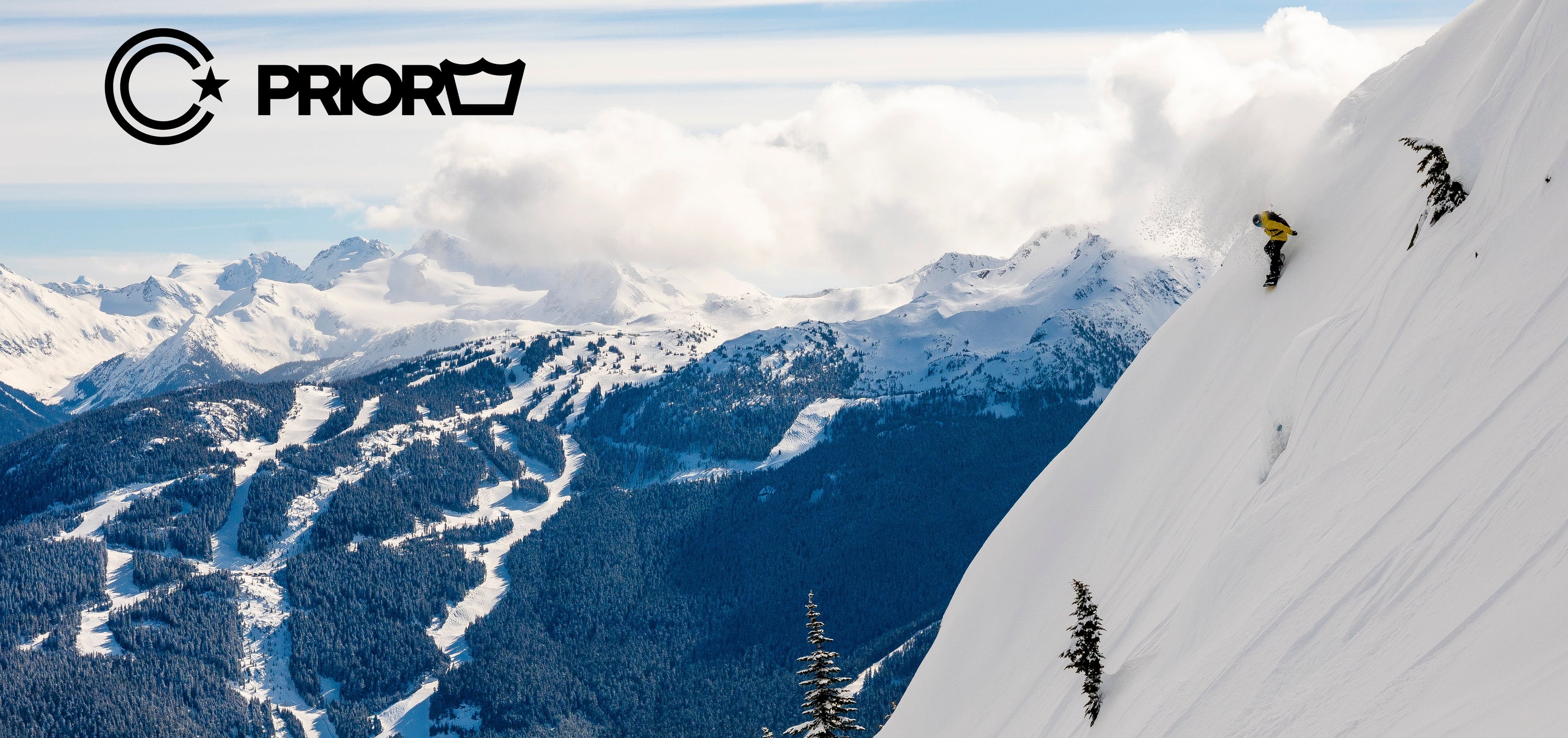 Person skiing down a snowy mountain with a scenic view of mountains and valleys below, featuring the brand 'Prior' at the top.